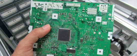 Holding a green printed circuit board.